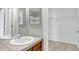 Bathroom features sink with tile countertop and access to a closet with wire shelving at 10646 Amesbury Way, Highlands Ranch, CO 80126