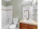 Neutral bathroom featuring a tiled shower-tub, cherry vanity and tile countertop with an undermount sink at 10646 Amesbury Way, Highlands Ranch, CO 80126