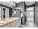Modern bathroom featuring dual sinks, tiled countertops, black and white floors, and grey painted walls at 10646 Amesbury Way, Highlands Ranch, CO 80126