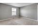 Empty room with grey walls, beige carpet, and a single window with blind coverings at 10646 Amesbury Way, Highlands Ranch, CO 80126