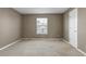 Empty room with tan walls, beige carpet, and a single window with blind coverings at 10646 Amesbury Way, Highlands Ranch, CO 80126