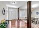 Bright entryway with hardwood floors, white door, a dark accent pillars, and a view to a dining space with natural light at 10646 Amesbury Way, Highlands Ranch, CO 80126
