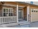 Charming front entryway with stone accents, covered porch, and a two-car garage at 10646 Amesbury Way, Highlands Ranch, CO 80126