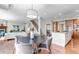 Open-concept kitchen with wooden cabinets, granite countertops, stainless steel appliances, and a view of the living and dining areas at 10646 Amesbury Way, Highlands Ranch, CO 80126