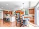 Well-lit kitchen with wood floors, granite countertops, stainless steel appliances, large island, and a round dining table at 10646 Amesbury Way, Highlands Ranch, CO 80126