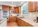 Well-lit kitchen featuring wood cabinets, granite countertops, stainless steel appliances, and a sink beneath a bright window at 10646 Amesbury Way, Highlands Ranch, CO 80126