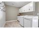 Laundry room with cabinets, coat hooks, utility sink, washer and dryer at 10646 Amesbury Way, Highlands Ranch, CO 80126