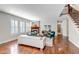 Bright living room featuring hardwood floors, a fireplace with a wooden mantle, and large windows with plantation shutters at 10646 Amesbury Way, Highlands Ranch, CO 80126