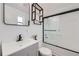 Modern bathroom featuring a vanity with a black faucet, a large mirror, and a shower-tub combo at 1537 Xenia St, Denver, CO 80220