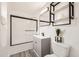 Modern bathroom with new vanity, black hardware, sleek mirror, and a shower-tub with glass doors at 1537 Xenia St, Denver, CO 80220