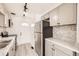 Updated kitchen with stainless steel refrigerator, marble countertop and backsplash, and modern lighting at 1537 Xenia St, Denver, CO 80220