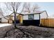 Beautiful home showcasing a contemporary black and white exterior, enhanced by wood accents and neat landscaping at 5261 Chandler Way, Denver, CO 80239