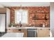 Modern kitchen with exposed brick, floating shelves, and light wood cabinets at 2809 Forest St, Denver, CO 80207