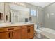 Bathroom featuring double vanities, a large mirror, and a tiled shower-tub combination with neutral tones at 1886 Makley Loop, Castle Rock, CO 80104