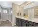 Bright bathroom featuring double sinks, a large mirror with modern lighting, and a glass-enclosed shower at 1886 Makley Loop, Castle Rock, CO 80104