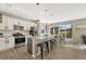 Open-concept kitchen boasts an island, white cabinets, stainless appliances, and an adjacent dining area at 1886 Makley Loop, Castle Rock, CO 80104