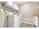 Clean and functional laundry room with a white front-load washer and dryer, and overhead storage at 1886 Makley Loop, Castle Rock, CO 80104