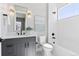 Bright bathroom features a shower over tub, grey vanity, and matte black fixtures at 1425 Burt Ave, Berthoud, CO 80513