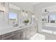 Bright and modern bathroom with double vanity featuring designer light fixtures at 1425 Burt Ave, Berthoud, CO 80513