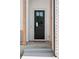 Stylish black front door with glass panels and a welcoming wreath, framed by wood columns and brick accents at 1425 Burt Ave, Berthoud, CO 80513