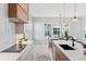 Modern kitchen showcasing an island with bar seating, cooktop, white countertops, and bright adjacent dining area at 1425 Burt Ave, Berthoud, CO 80513