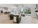 Open-concept living room with large windows, hardwood floors, and a modern design at 1425 Burt Ave, Berthoud, CO 80513