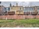Backyard view featuring multiple decks and a charming pink fence with grassy common area at 1240 S Idalia St, Aurora, CO 80017