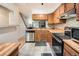 An inviting kitchen with wood cabinets, stainless steel appliances, and an open view to the living area at 1240 S Idalia St, Aurora, CO 80017