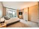 Well-lit bedroom with carpet, large window, and a television on a dresser at 8100 E Union Ave # 310, Denver, CO 80237