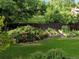 Lush backyard featuring a well-manicured lawn, a charming rose garden, and raised garden beds at 14475 Crabapple Rd, Golden, CO 80401