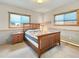 Comfortable bedroom with wood trim, a bed with a quilt, and natural light from windows at 14475 Crabapple Rd, Golden, CO 80401
