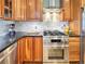 Close up of stainless steel appliances, marble backsplash and butcher block countertops in the kitchen at 14475 Crabapple Rd, Golden, CO 80401