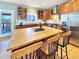 Open kitchen with wooden cabinets, butcher block island, and adjacent breakfast nook with natural light at 14475 Crabapple Rd, Golden, CO 80401