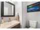 Powder room features a sleek vanity, modern faucet, and colorful painting at 2016 W 101St Ave, Thornton, CO 80260