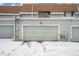 Attached one-car garage in winter with light gray door and snowy driveway at 2016 W 101St Ave, Thornton, CO 80260