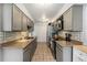 Functional kitchen featuring sleek countertops, tile backsplash, and a range of modern appliances at 2016 W 101St Ave, Thornton, CO 80260