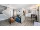 Bright living room with hard wood floors, gray couch, and a view into the adjacent kitchen and dining area at 2016 W 101St Ave, Thornton, CO 80260