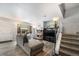 Open-concept living room with a cozy fireplace, staircase access, and an abundance of natural light at 2016 W 101St Ave, Thornton, CO 80260