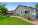 Landscaped backyard features a patio, dining set, fire pit, grill, and well-maintained lawn at 18496 Keyser Creek Ave, Parker, CO 80134