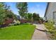 Green backyard with patio, dining set, garden bed, and privacy fence offers relaxation at 18496 Keyser Creek Ave, Parker, CO 80134