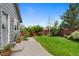 Spacious backyard with a lush lawn, wooden fence, a garden, a patio, and attractive landscaping at 18496 Keyser Creek Ave, Parker, CO 80134