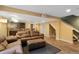 Finished basement with a large sofa, wood floors, and a projector setup at 18496 Keyser Creek Ave, Parker, CO 80134