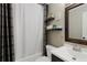 Bathroom featuring a shower with a curtain, shelving, and a vanity with a sink and mirror at 18496 Keyser Creek Ave, Parker, CO 80134