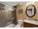 Bright bathroom featuring a glass shower door, round mirror, and granite countertop with a sink at 18496 Keyser Creek Ave, Parker, CO 80134