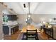 Open dining and kitchen area features a butcher block table, modern decor, and dark wood floors at 18496 Keyser Creek Ave, Parker, CO 80134