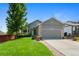 Charming single-Gathering home boasts a well-manicured lawn, mature tree, and inviting curb appeal on a sunny day at 18496 Keyser Creek Ave, Parker, CO 80134