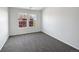 Bright bedroom featuring plush gray carpet, two windows, and neutral walls at 12713 Leyden St # E, Thornton, CO 80602