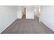 Bedroom with gray carpet, white walls, and doorways, with an open white door at 12713 Leyden St # E, Thornton, CO 80602