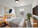 Bright bedroom featuring natural wood bed frame, light gray walls, modern art, and large window at 12713 Leyden St # E, Thornton, CO 80602