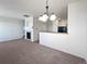 Spacious living room featuring a fireplace, chandelier, and open view to the kitchen area at 12713 Leyden St # E, Thornton, CO 80602